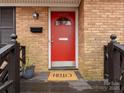 Close-up view of the inviting red front door with a 'HELLO' doormat and a mailbox at 3350 Bonneville Dr, Charlotte, NC 28205