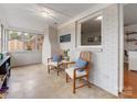 A sunroom with white brick walls and hardwood floors, offering a comfortable seating area at 3350 Bonneville Dr, Charlotte, NC 28205