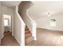 Hallway with staircase and vinyl flooring, with a view of the powder room, and the living room at 3410 Saddlebred Dr, Gastonia, NC 28052