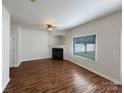 Living room featuring wood floors, white walls, a fireplace, and a window at 3937 Northerly Island Ct, Gastonia, NC 28056