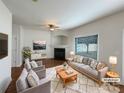 Bright living room with fireplace, wood floors, neutral furniture and a large window at 3937 Northerly Island Ct, Gastonia, NC 28056