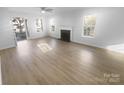 Bright and spacious living room featuring new flooring, fireplace, and large windows at 4219 Robinwood Dr, Charlotte, NC 28212