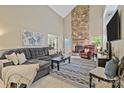 Open living room with stone fireplace, plush seating, and abundant natural light at 5084 Mariana Ct, Tega Cay, SC 29708