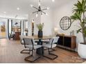 Dining area with modern lighting, table, and chairs, with view into the kitchen at 5731 Castlerea Dr, Charlotte, NC 28217