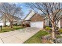 Brick home with a two-car garage, mature trees, and a well-maintained lawn, perfect for curb appeal at 620 Amethyst Cir, Fort Mill, SC 29708