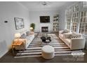 Bright living room with fireplace, large windows, neutral décor, and tastefully coordinated furniture at 6318 Pink Dogwood Ln, Charlotte, NC 28262
