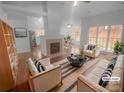 Bright and airy living room featuring a fireplace, hardwood floors, and large windows at 6809 Brancusi Ct, Charlotte, NC 28215