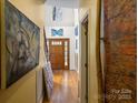 Hallway with wood floors, high ceilings, artwork, and a view of the front door at 732 Ellsworth Rd, Charlotte, NC 28211