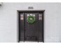 Close up of the front door with a green wreath on a white brick home at 805 East St, Albemarle, NC 28001