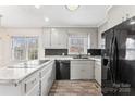 Cozy kitchen featuring gray cabinets, black appliances, black backsplash, and wood flooring at 822 Bethlehem Rd, Kings Mountain, NC 28086