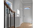 Inviting foyer showcasing a white front door, wood floors, and a decorative staircase at 8233 Houser St, Cornelius, NC 28031