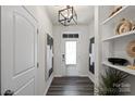 Welcoming foyer features wood-look flooring, modern light fixture, and stylish shelving with decorative items at 9042 Northfield Crossing Dr, Charlotte, NC 28269