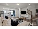 Open-concept living room with a comfortable sofa, adjacent to the kitchen and featuring a staircase at 9042 Northfield Crossing Dr, Charlotte, NC 28269