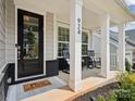 Inviting front porch featuring rocking chairs, white columns, and a decorative front door at 924 Stebbins Dr, Fort Mill, SC 29715