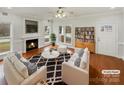 Bright living room featuring hardwood floors, a cozy fireplace, modern furniture, and large windows at 104 Tarrington Dr, Statesville, NC 28625
