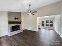 Bright living room featuring a brick fireplace and seamlessly transitioning to a sunlit kitchen area at 106 Cape Breton Trl, Gastonia, NC 28056