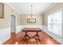 Classic dining room features wood floors, traditional chandelier, and large window for natural light at 10615 Persimmon Creek Dr, Mint Hill, NC 28227