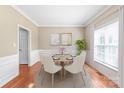 Bright dining room featuring hardwood floors, a round table with six chairs, and decorative wall art at 10615 Persimmon Creek Dr, Mint Hill, NC 28227