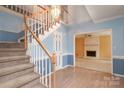 Bright foyer featuring staircase, hardwood floors, and views into the living room with fireplace at 10914 Ridge Acres Rd, Charlotte, NC 28214