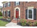 Inviting front entrance showcasing a classic red door with decorative trim and wrought iron railings at 10914 Ridge Acres Rd, Charlotte, NC 28214