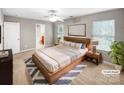 Staged main bedroom with a modern wood bed frame, ensuite access, and carpeted floors at 114 Sheridan Ct, Mooresville, NC 28115