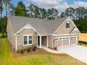 Attractive single-Gathering home featuring a three-car garage, stone accents, and a well-maintained lawn at 13101 Cozy Ct, Charlotte, NC 28215