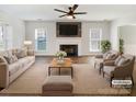 Bright living room features a fireplace, ceiling fan, and a neutral color palette at 13424 Kibworth Ln, Charlotte, NC 28273