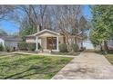 Beautifully landscaped home featuring a quaint front porch, a private driveway, and a detached garage at 1409 Cortland W Rd, Charlotte, NC 28209