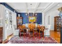 A formal dining room featuring a coffered ceiling, blue accent wall, and a large chandelier, perfect for entertaining at 19118 Betty Stough Rd, Cornelius, NC 28031