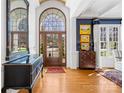 Elegant foyer featuring hardwood floors, a large arched doorway, and decorative furniture with natural lighting at 19118 Betty Stough Rd, Cornelius, NC 28031