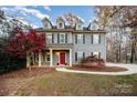 Two-story home featuring dormer windows and a red front door, surrounded by landscaped yard and trees at 2101 Darian Way, Waxhaw, NC 28173