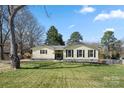 Inviting one-story home featuring a beautiful lawn, mature trees, and classic black shutters at 2413 Hoffman St, Gastonia, NC 28054