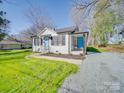 Quaint single-story home boasts a bright blue door, covered porch, and a lush green lawn at 407 E Talleyrand St, Monroe, NC 28112
