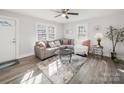 Bright living room featuring a gray sectional sofa, decorative pillows, and natural light at 407 E Talleyrand St, Monroe, NC 28112
