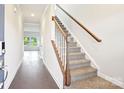 Inviting entryway showcasing a staircase with wooden banister and sleek laminate flooring at 410 Luna Ln, Shelby, NC 28152