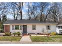 Charming single-story home featuring a white exterior, gray accents, and a welcoming brick pathway at 4820 Valley Stream Rd, Charlotte, NC 28209