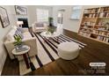 Bright, staged living room with modern furniture, decorative fireplace, hardwood floors and a stylish bookshelf at 4906 Lynn Lee Cir, Charlotte, NC 28269