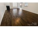 Open concept living room featuring hardwood floors, fireplace, and a seamless flow to the kitchen space at 4906 Lynn Lee Cir, Charlotte, NC 28269