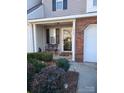 Inviting covered front porch featuring a bench, stylish door, and landscaped garden at 5963 Moose Ln, Charlotte, NC 28269