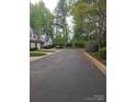 Quiet neighborhood street with mature trees, manicured lawns, and townhomes at 5963 Moose Ln, Charlotte, NC 28269