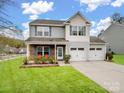 Charming two-story home with a two-car garage, a stone-accented porch, blue shutters, and a manicured lawn at 629 Gants Rd, York, SC 29745