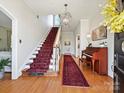 Grand foyer with hardwood floors, a staircase with a red runner and an ornate chandelier at 638 Forest Ln, Rock Hill, SC 29730
