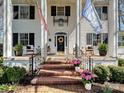 Close up of the front of the two-story home with a covered front porch, brick steps and seating at 638 Forest Ln, Rock Hill, SC 29730