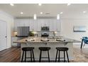 Modern kitchen with a large island, stainless steel appliances, granite countertops, and stylish pendant lighting at 6450 Keeton Ln, Harrisburg, NC 28075