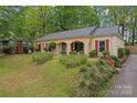 Traditional single-story home with brick facade, red shutters, and mature landscaping at 6721 Old Post Rd, Charlotte, NC 28212