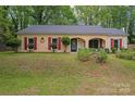 Traditional single-story home with brick facade, red shutters, and lush landscaping at 6721 Old Post Rd, Charlotte, NC 28212