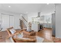 Open-concept living space blending the kitchen and living area, featuring stairs and a view of the front entrance at 6914 Idlewild Rd, Charlotte, NC 28212