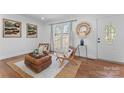 Cozy living room with woven chairs, area rug, and ample natural light from the front window at 6914 Idlewild Rd, Charlotte, NC 28212