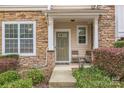Close-up of a charming front porch with stone accents, a cozy seating area, and a welcoming entrance at 8009 Whitehawk Hill Rd, Waxhaw, NC 28173