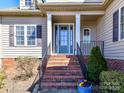 Elegant front entrance with a blue door, brick steps, and decorative landscaping at 816 Springs Rd, Dallas, NC 28034